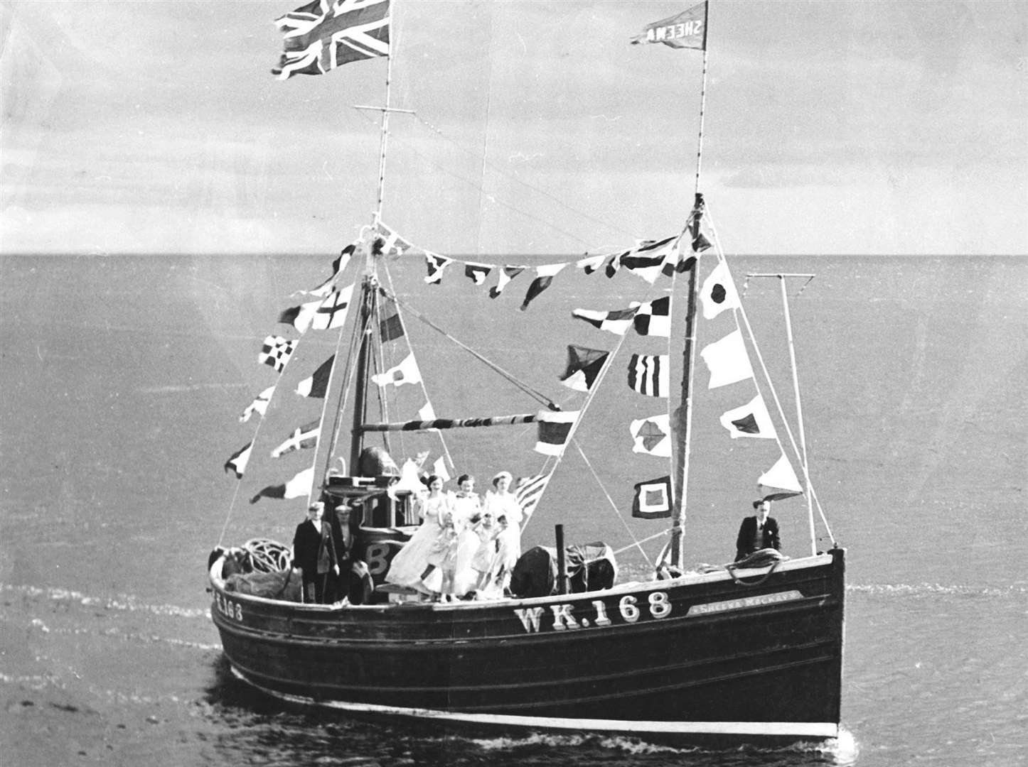 The Wick-registered boat Sheena Mackay entering Helmsdale harbour during the 1950s, with the Seine Queen and her attendants on board.