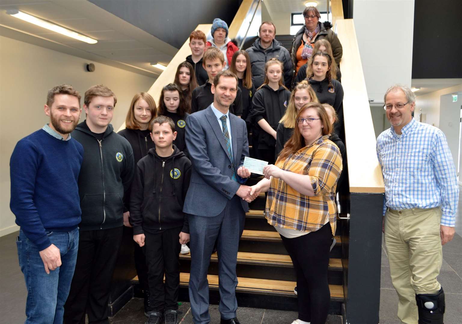 Mrs Sam Manson, secretary of the newly formed Wick High School Parent Council, handing over cheques totalling £750 to acting rector Sebastian Sandecki with pupils who attend the school's inventors' and textiles clubs looking on. Pictures: Julia M Dunnet