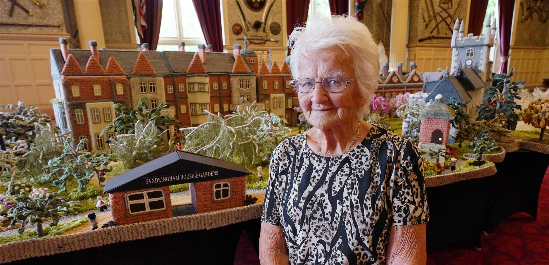 Margaret Seaman, 93, of Caister-on-Sea in Norfolk, stands next to her ‘Knitted Sandringham’ (Yui Mok/PA)