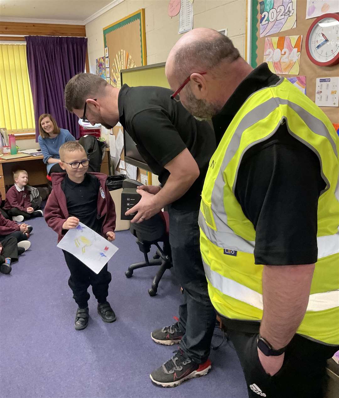 Runner-up Jaxon Garrett-Atkins from Dunbeath Primary School receiving his prize from Dounreay's James Steven and Rob Macleod.