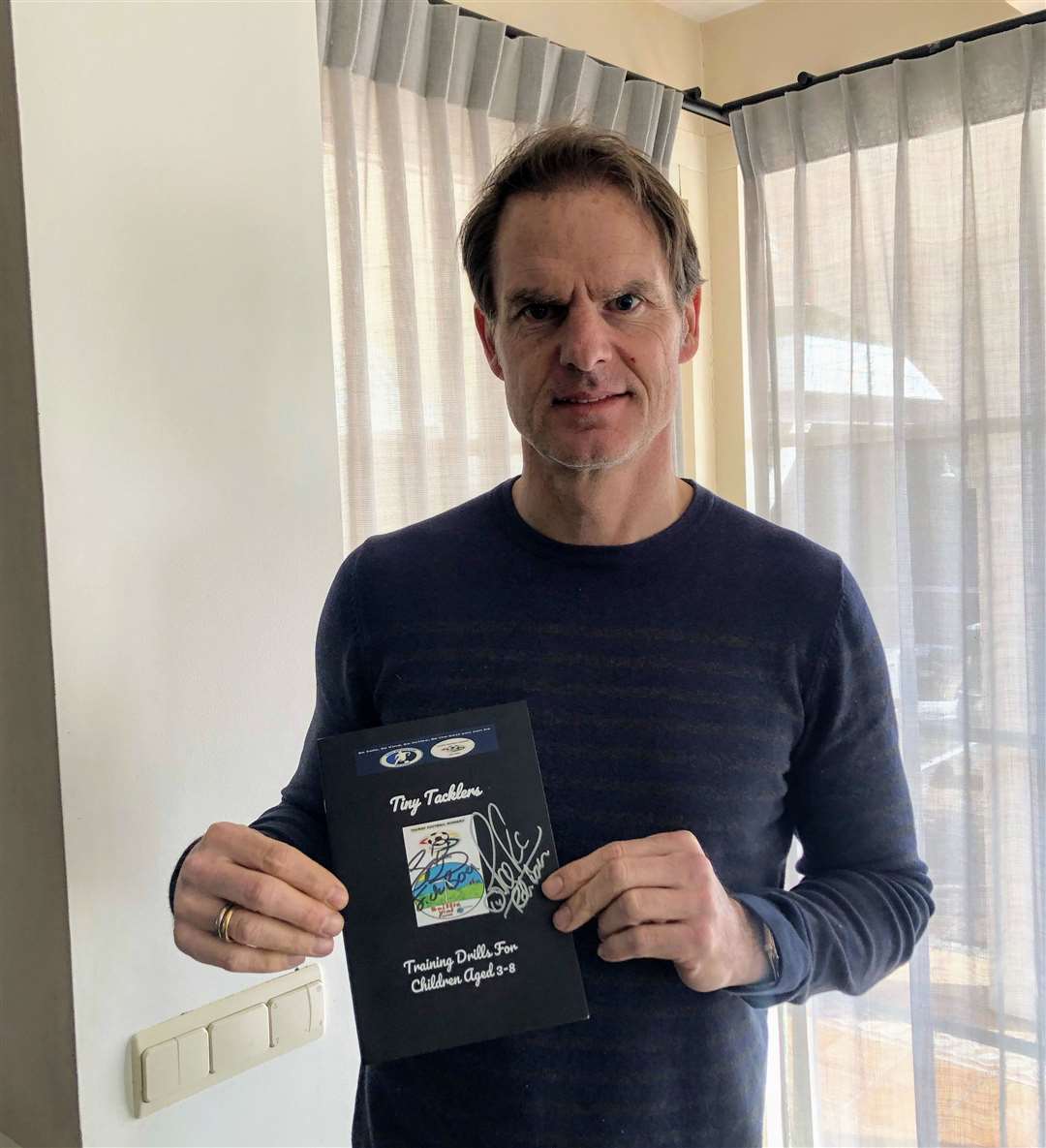 Dutch national team manager Frank de Boer with a signed copy of the Tiny Tacklers booklet from Thurso Football Academy.