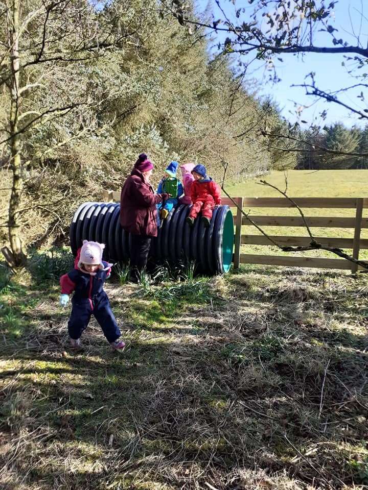 Senior early years practitioner Fiona Murray and some children playing in the woodland area. Picture: Sharon Dismore