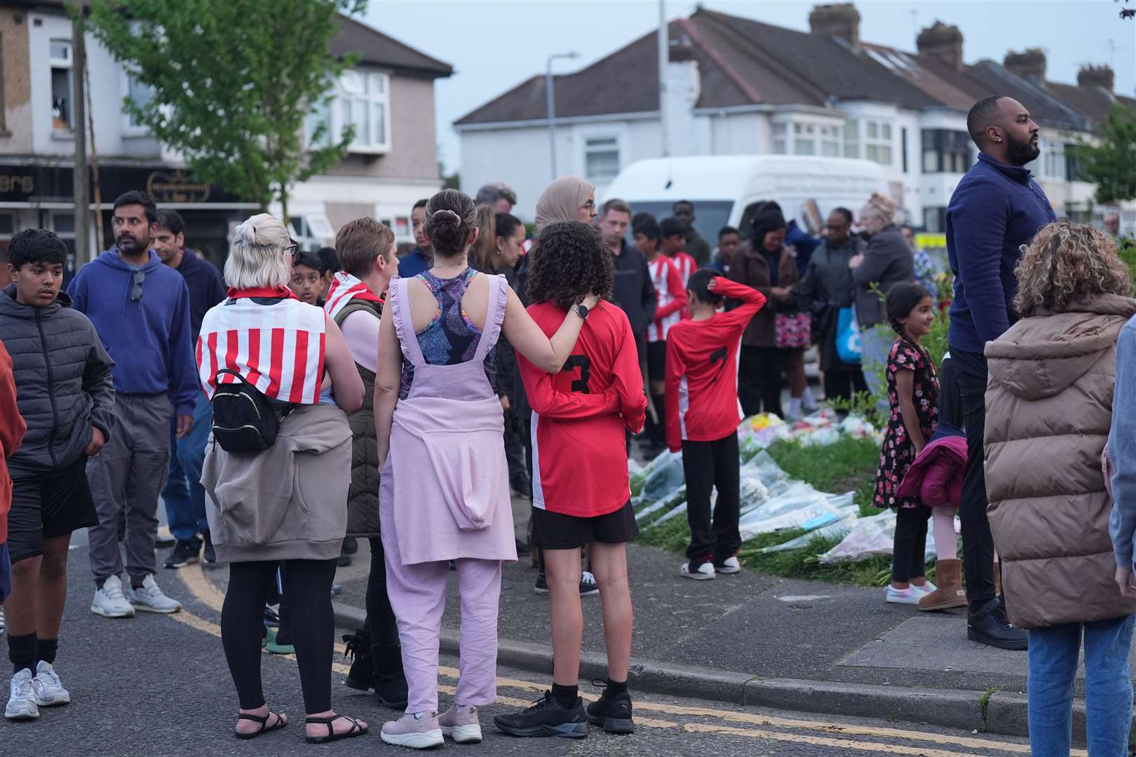 Members of the community look at floral tributes in Hainault (Yui Mok/PA)