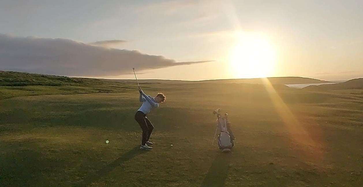 Arran Johnson, winner of round 13 of the Abbott Risk Consulting Summer Cup, playing the second hole at Reay with the sun setting.