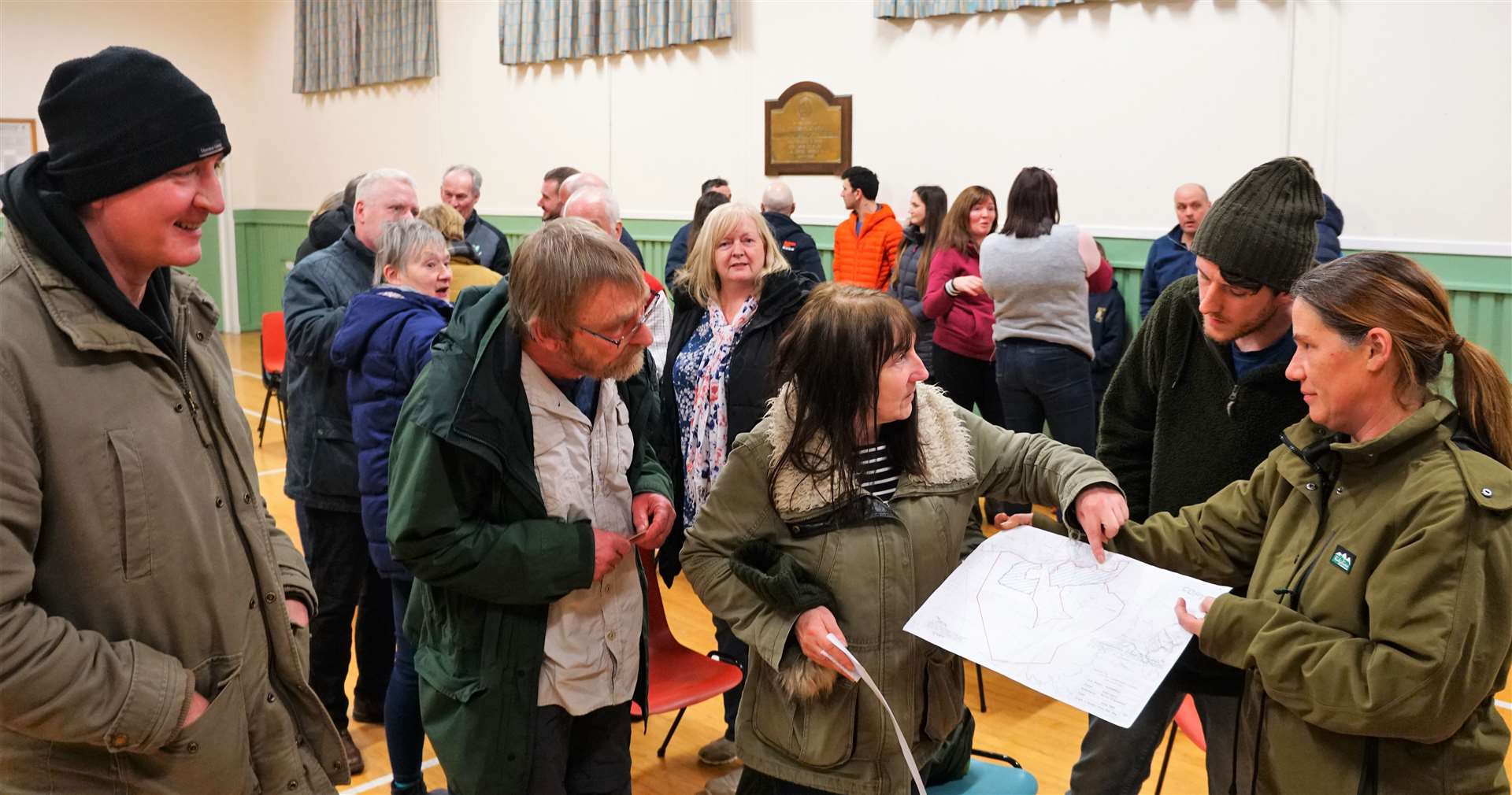 Bib points to a document showing a plan of the proposed wind farm development at West Watten. Other objectors are pictured with her at a meeting in Watten village hall. Picture: DGS