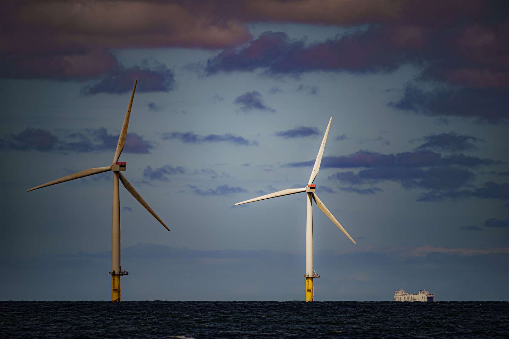 A ship passing wind turbines (Ben Birchall/PA)