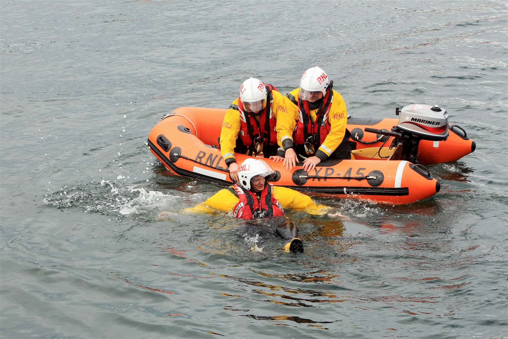 Lifeboat crew members giving a rescue demonstration in the harbour using their XP dinghy. Picture: Alan Hendry