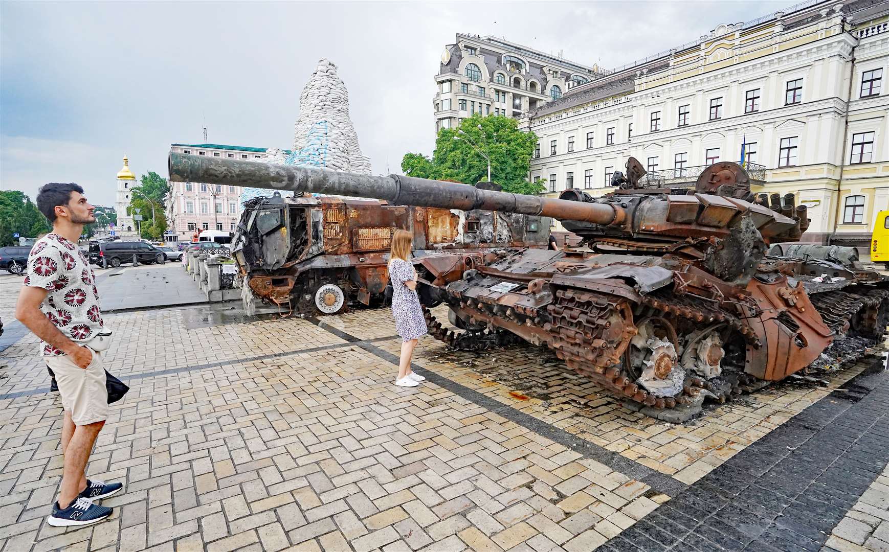 A man looks down the barrel of a destroyed Russian tank displayed St Michael’s Square, Kyiv Ukriaine (PA)