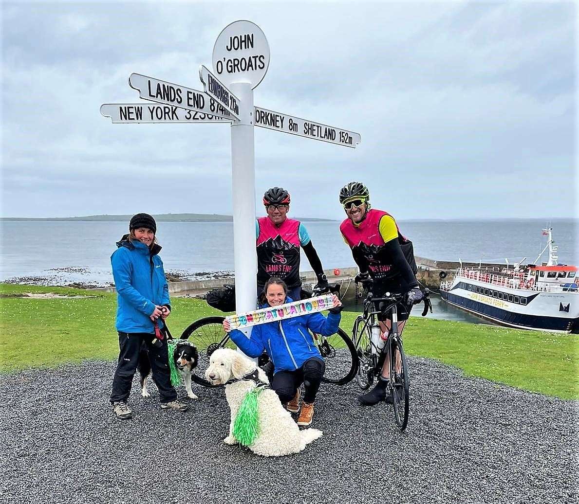 End of the road celebrations for the cycling pair. Pictured with Edward and Phill are their wives Emma Jenner and Clare Ryan, holding banner, along with dogs Luna and Cassie.