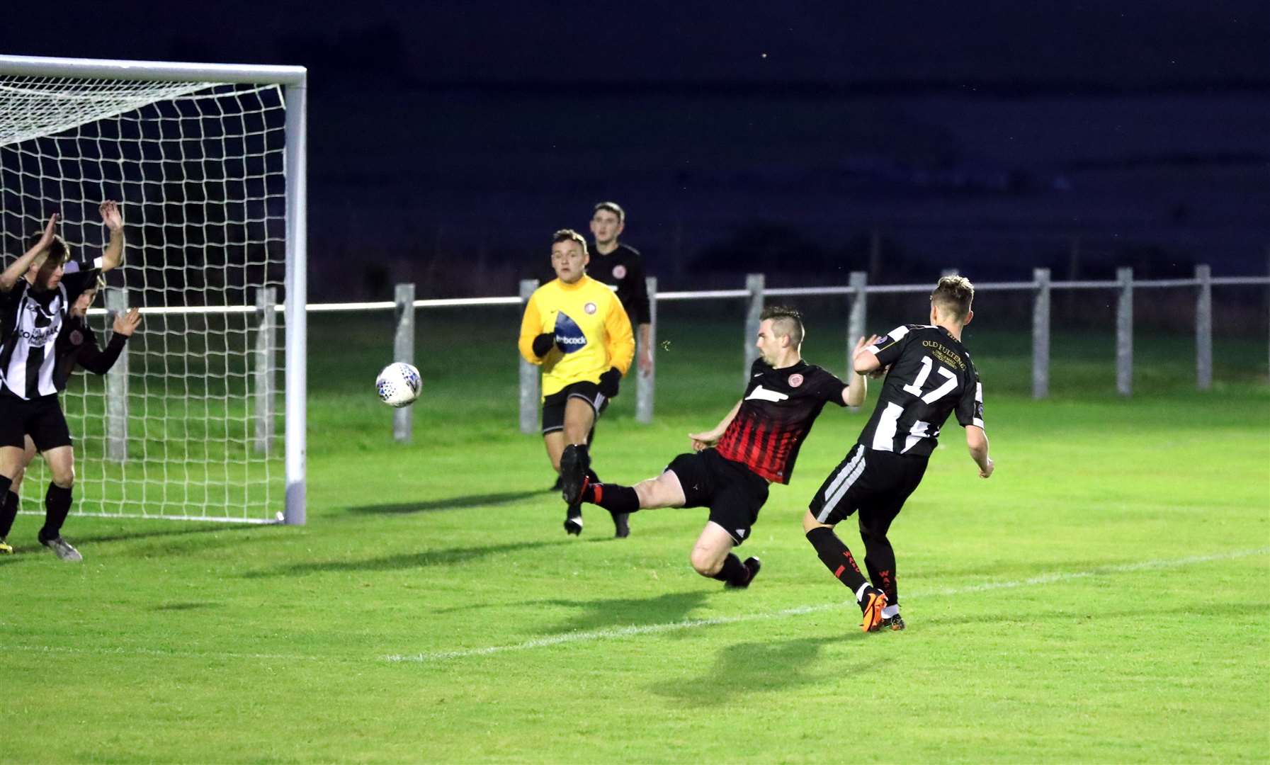 Wick Academy's Mark Macadie gets on the scoresheet as he sends the ball past Halkirk defender John Budge. Picture: James Gunn