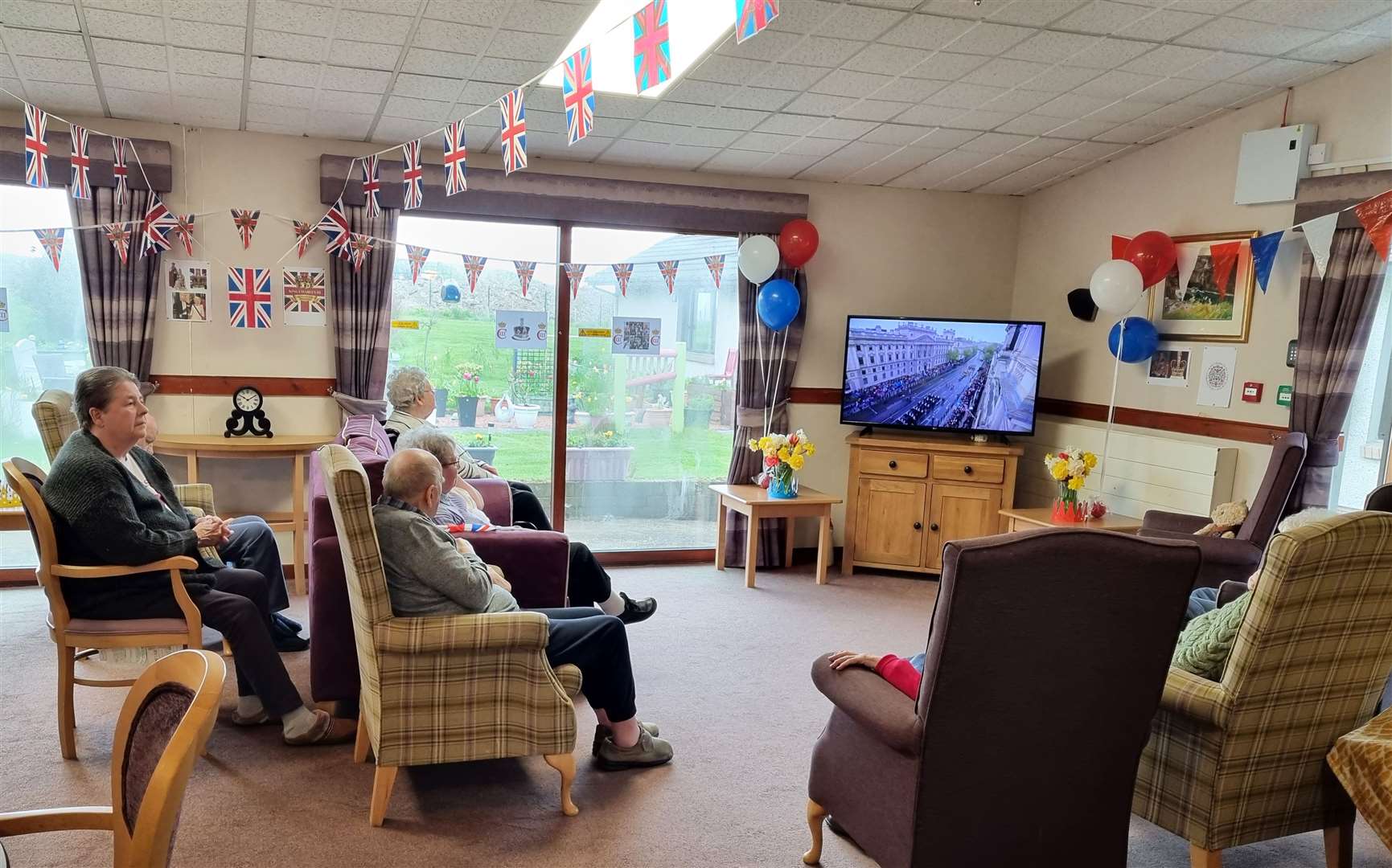 Seaview House residents avidly watching the coronation coverage on TV.