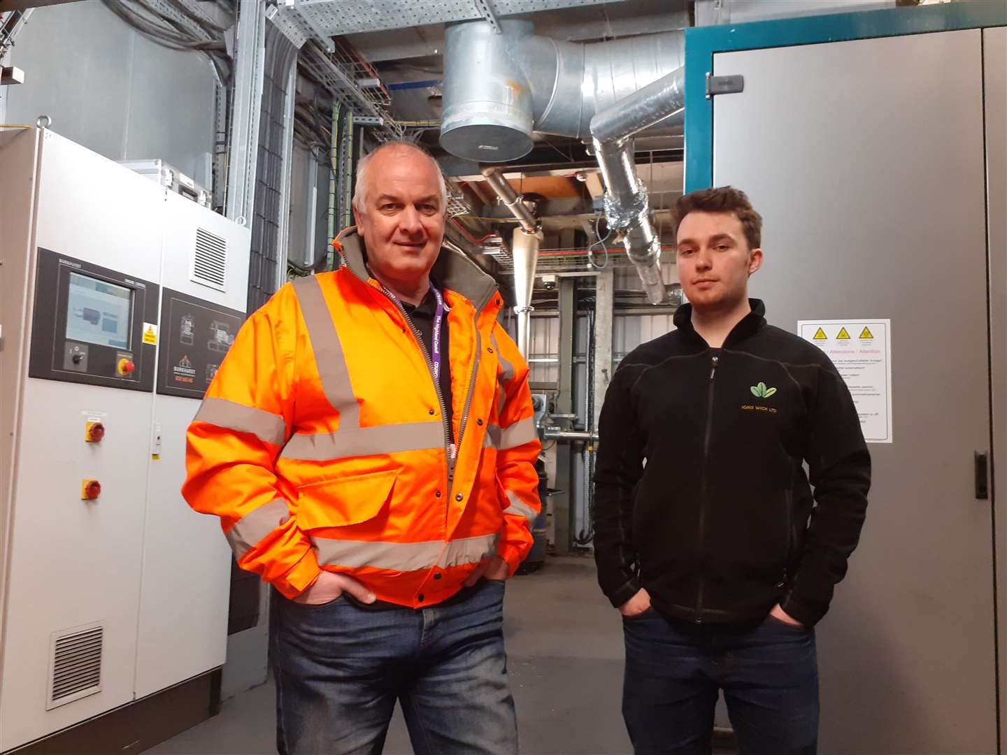 Councilor Raymond Bremner (left) and Harris Gilmore, director of Ignis Wick Ltd, inside the biomass plant.