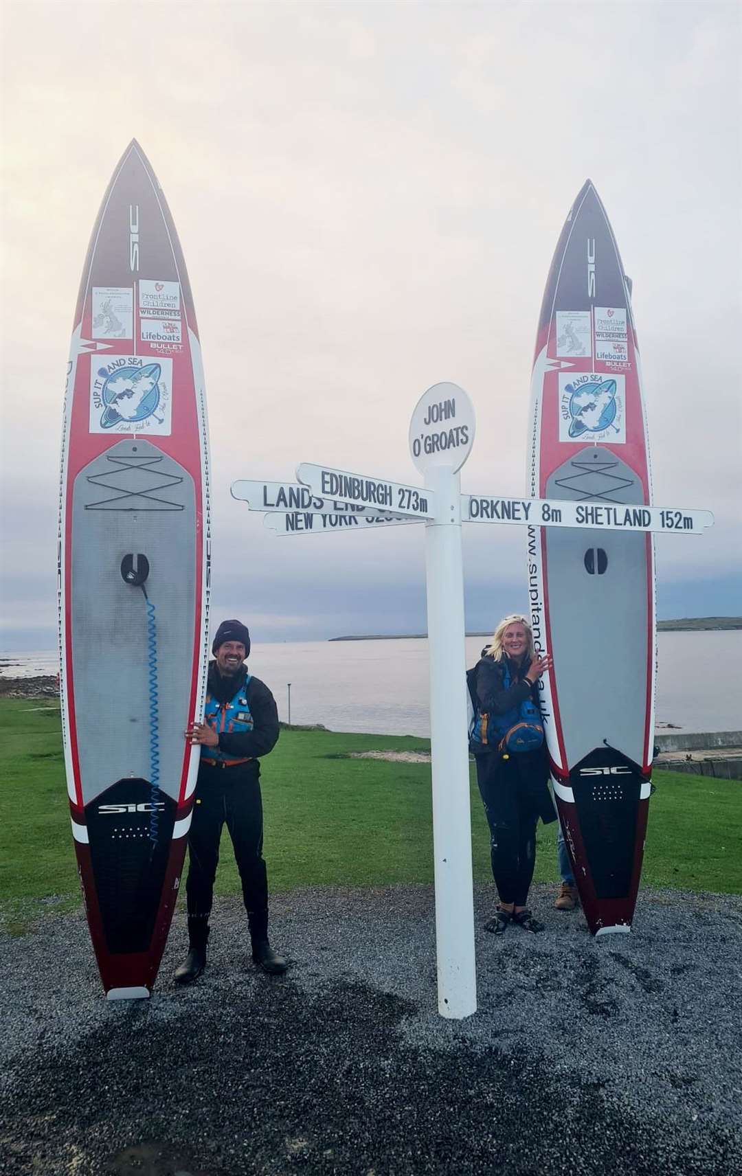 Dave and Sophie with their paddleboards after arriving at John O'Groats.