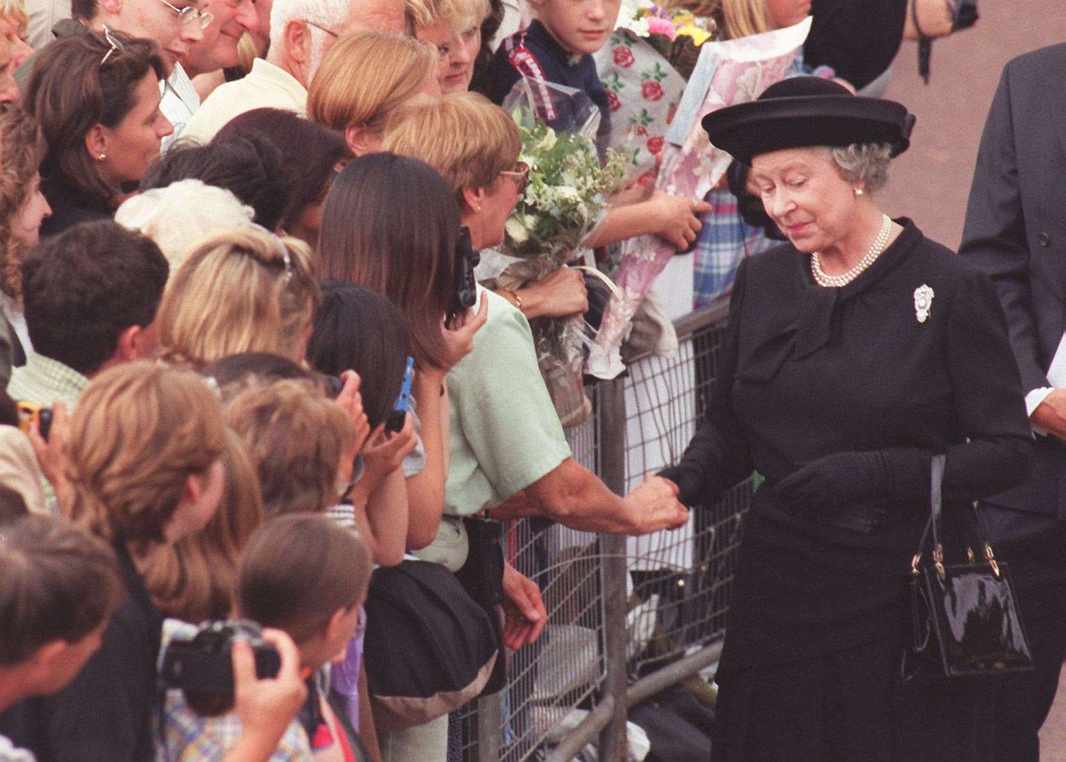 Dressed in black, the Queen meets the crowds of mourners outside Buckingham Palace after arriving for the funeral of her former daughter-in-law Diana, Princess of Wales (John Giles/PA)