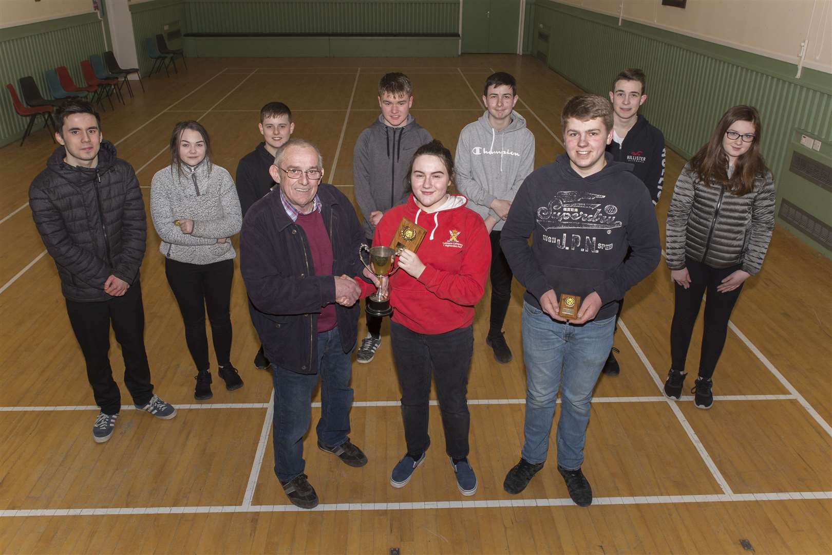 Caithness Small Bore Rifle Association's junior indoor champion Caitlin Green, of Westfield, receives her trophy from George Baikie. Runner-up was her clubmate Murray Mackenzie (front right). Looking on are the other juniors who took part in the final – (from left) Andrew Morrison, Westfield; Mollie Mackay, Watten; and Robbie Levack, Adam Bremner, Ross Sutherland, Alistair Campbell and Sophie Campbell, all Halkirk. The competition was held in Watten hall on Monday night. Picture: Robert MacDonald / Northern Studios