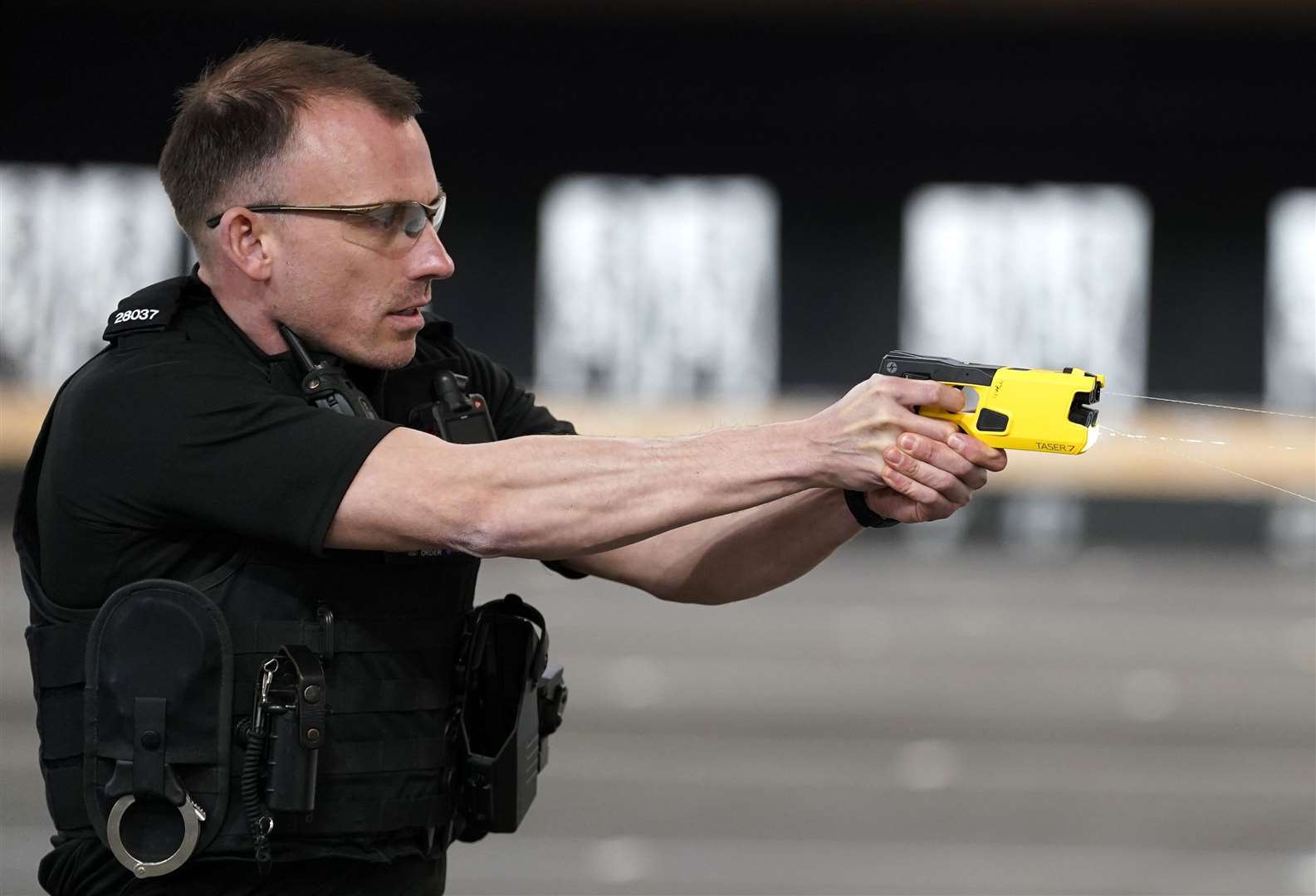 An officer demonstrates the Taser 7 which has two cartridge types for use depending on the proximity of a person (Andrew Matthews/PA)