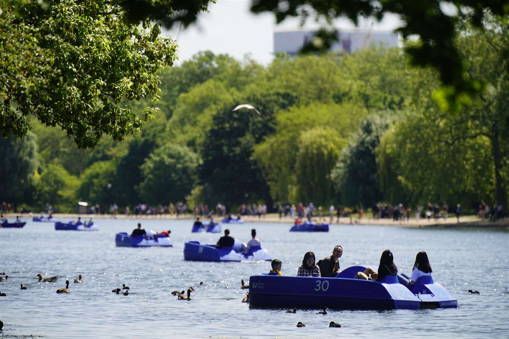 People ride pedalo and rowing boats in the hot weather on the Serpentine in Hyde Park, London (Aaron Chown/PA)