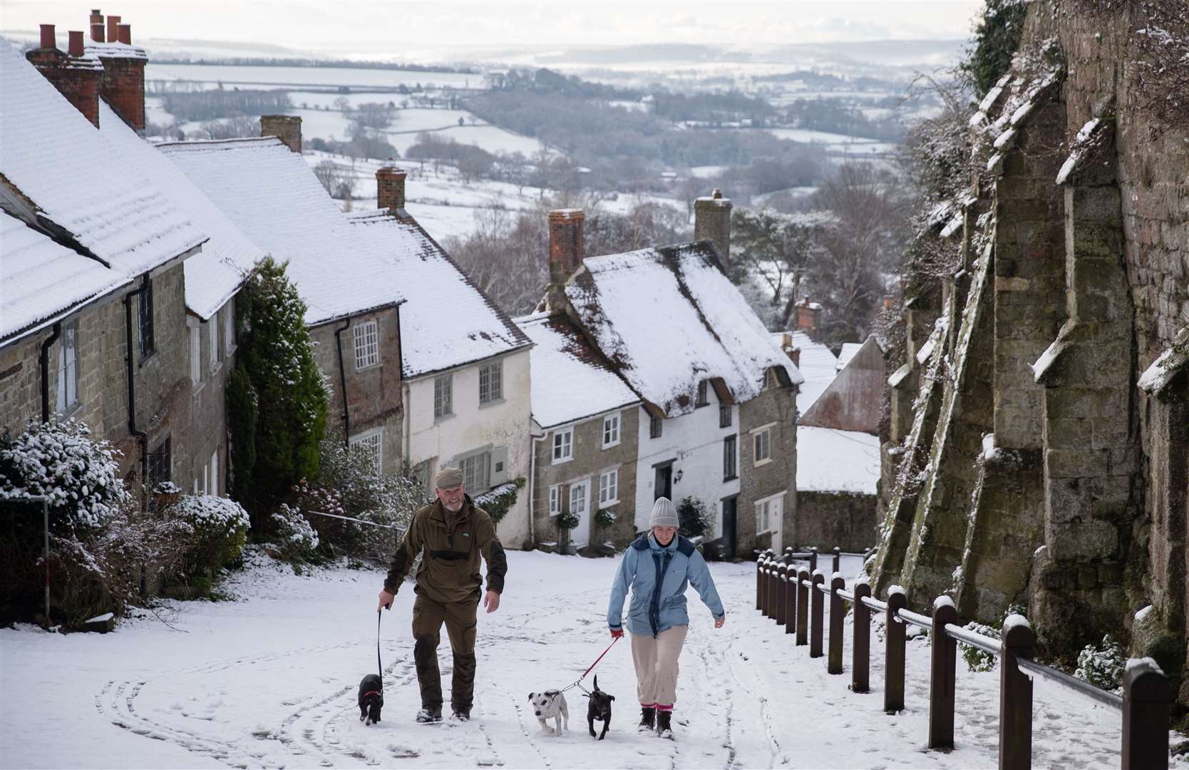Dog walkers on a snowy Gold Hill (Andrew Matthews/PA)