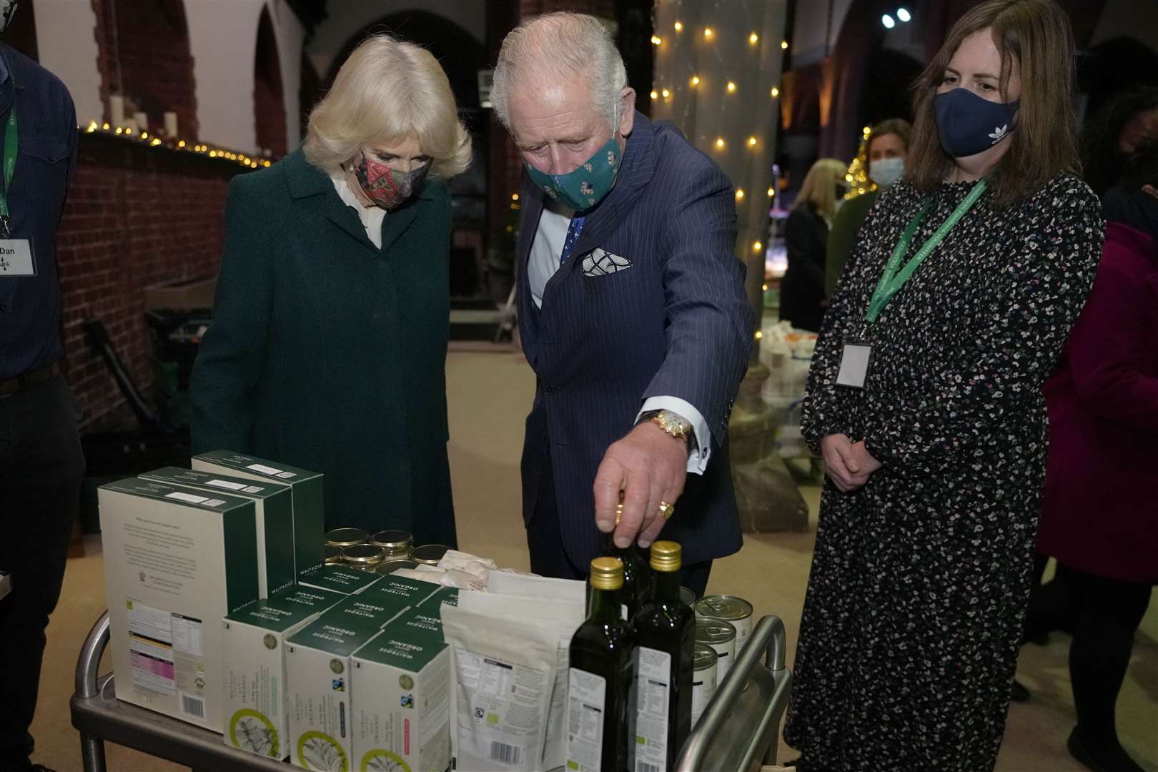 The Prince of Wales and Duchess of Cornwall look at donated items during a visit to Wandsworth Foodbank (Kirsty Wigglesworth/PA)