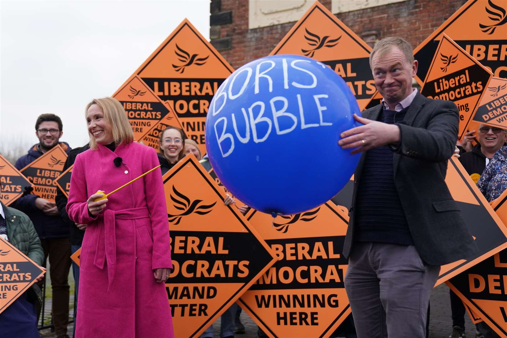 Helen Morgan bursting ‘Boris’ bubble’ held by colleague Tim Farron (Jacob King/PA)