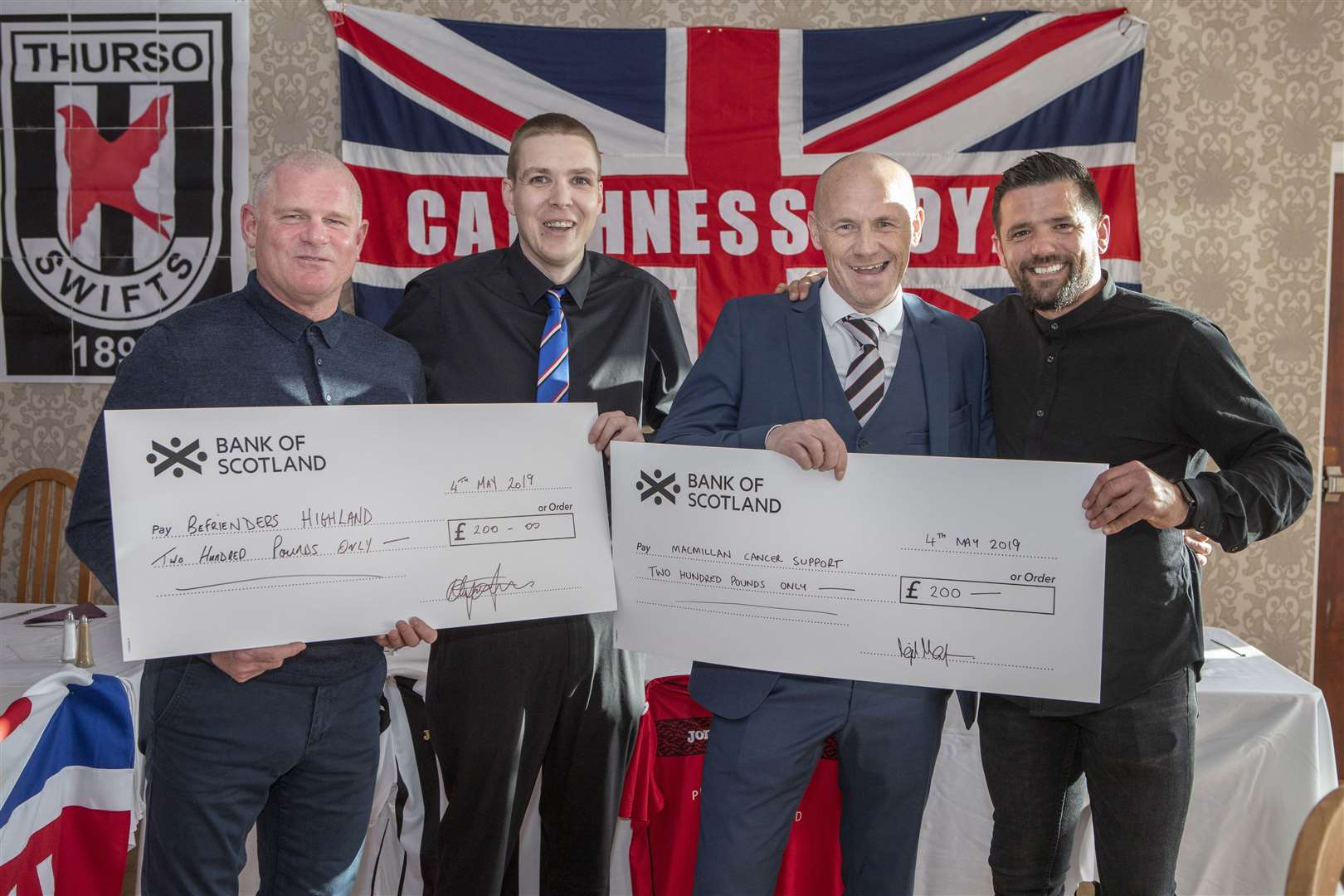Alyn Gunn (second from left) and Nigel Mackenzie (second from right) with the charity cheques for Befrienders Highland and Macmillan Cancer Support, held here by Ian Durrant and Nacho Novo. Picture: John Baikie