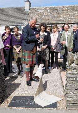 Prince Charles unveils the plaque at the entrance to the two 19th-century flagstone cottages he officially opened on Monday. Photo: Ann-Marie Jones / Northern Studios.