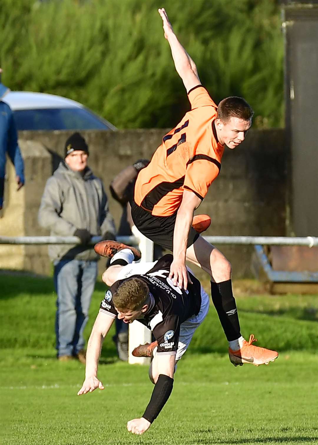 Wick's Ross Allan finds himself carrying the weight of Craig Cormack of Rothes on his shoulders. Picture: Mel Roger