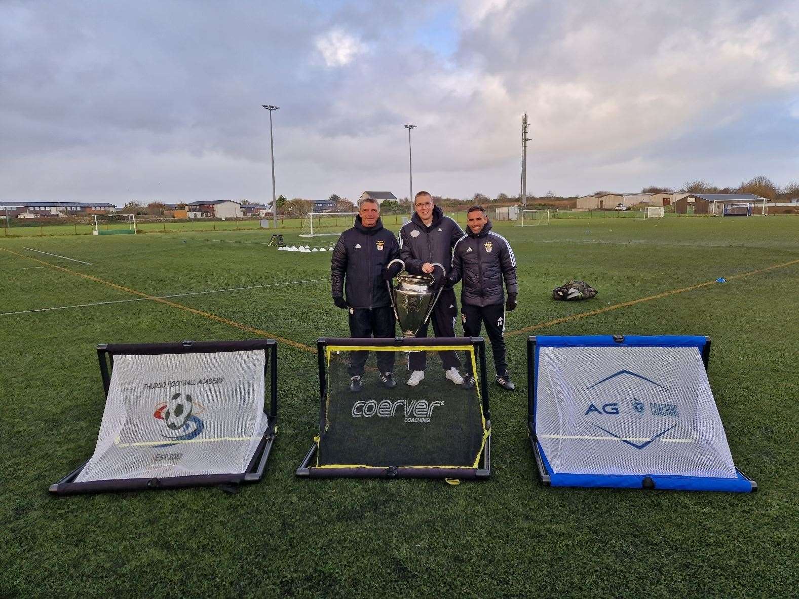 Benfica coaches Joao Rosmaniho and Serguei Kandaurov, pictured with Thurso Football Academy head of coaching Alyn Gunn, brought a replica of the European Cup to Caithness.