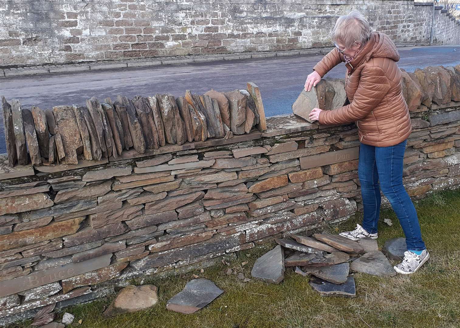 Yvonne Hendry, secretary of Second World War Air Raid Victims Wick, putting coping stones back in place.