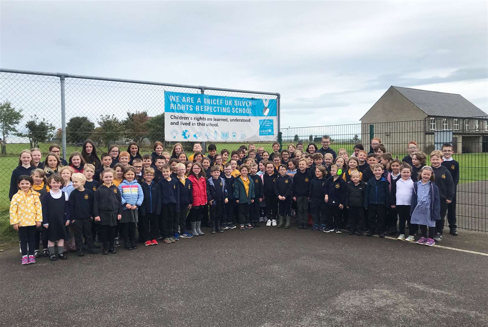 Halkirk primary pupils showing off the Rights Respecting School banner the school received.