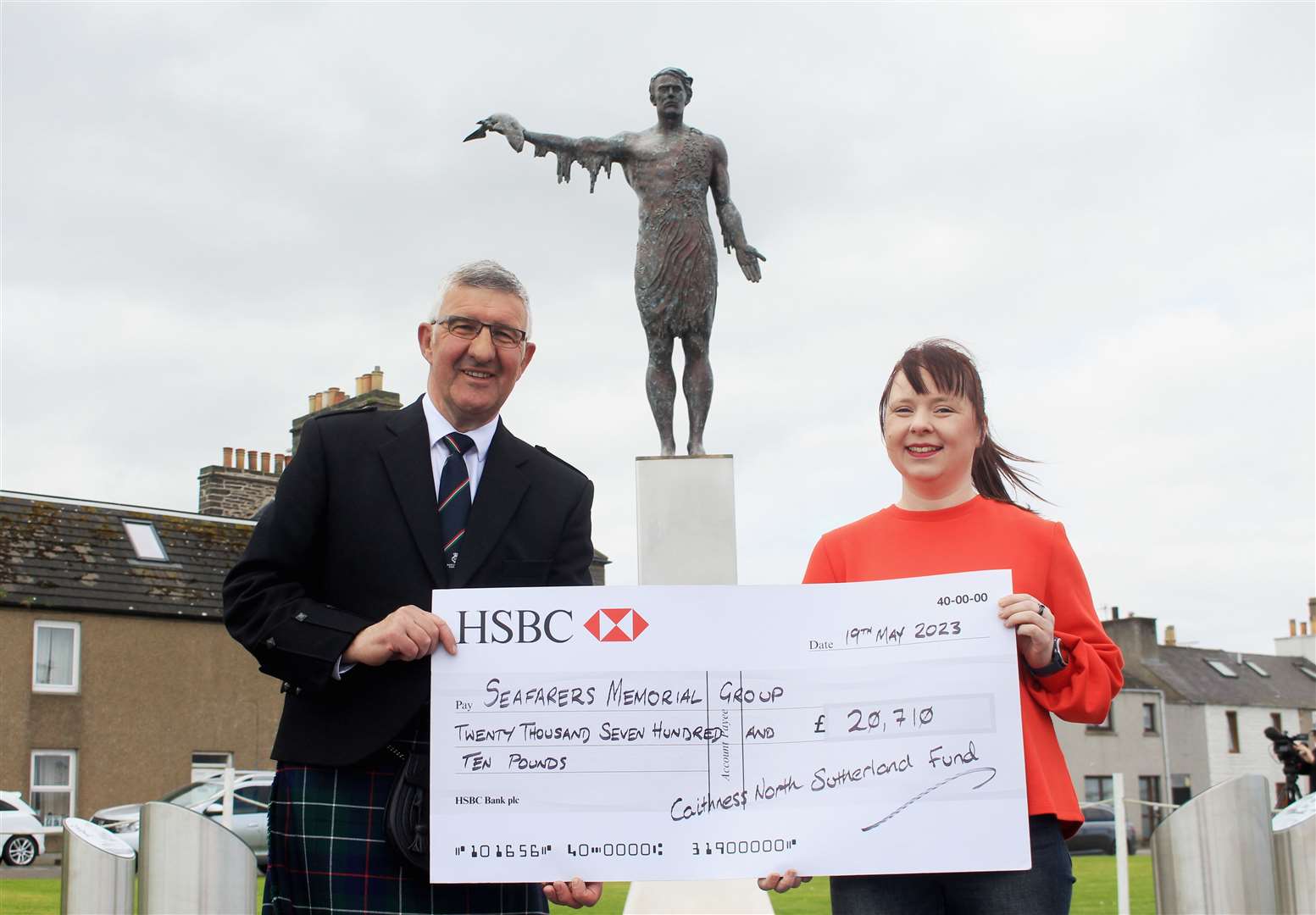 Willie Watt, chairman of the Seafarers Memorial Group, accepts a cheque for £20,710 from Kayleigh Nicolson, vice-chairperson of the Caithness and North Sutherland Fund. Picture: Alan Hendry