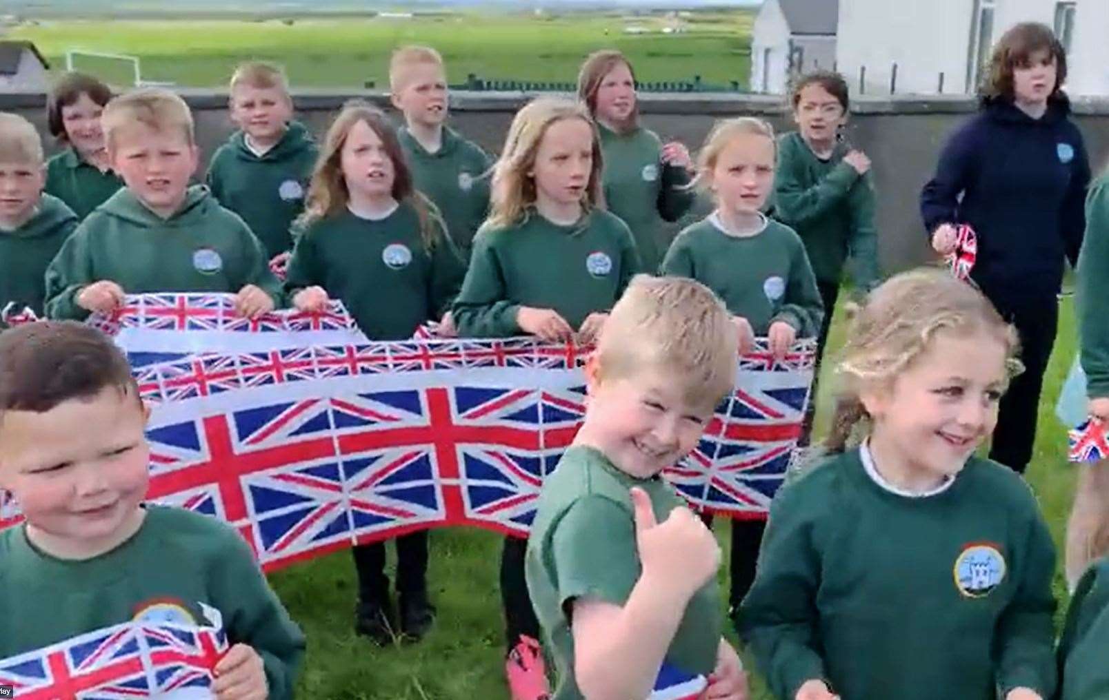 Thumbs-up for Her Majesty in this screenshot from the Keiss Primary School video of Sweet Caroline.