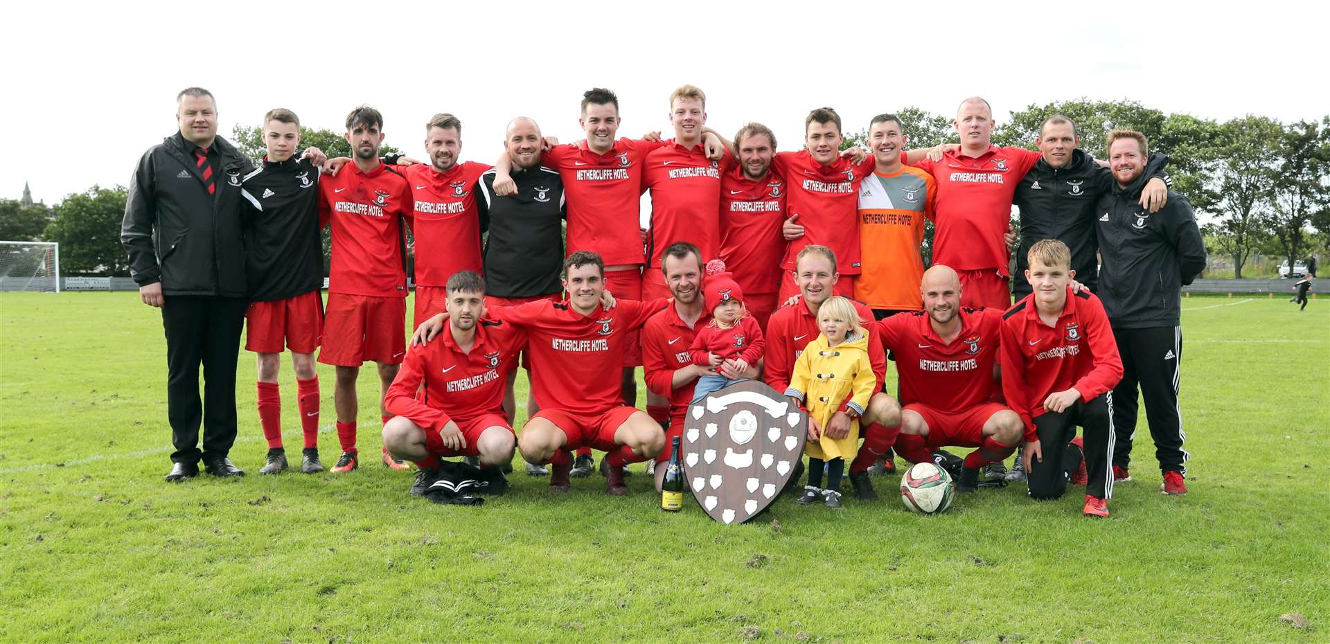 A victorious Wick Groats squad and officials with the David Allan Shield. Picture: James Gunn