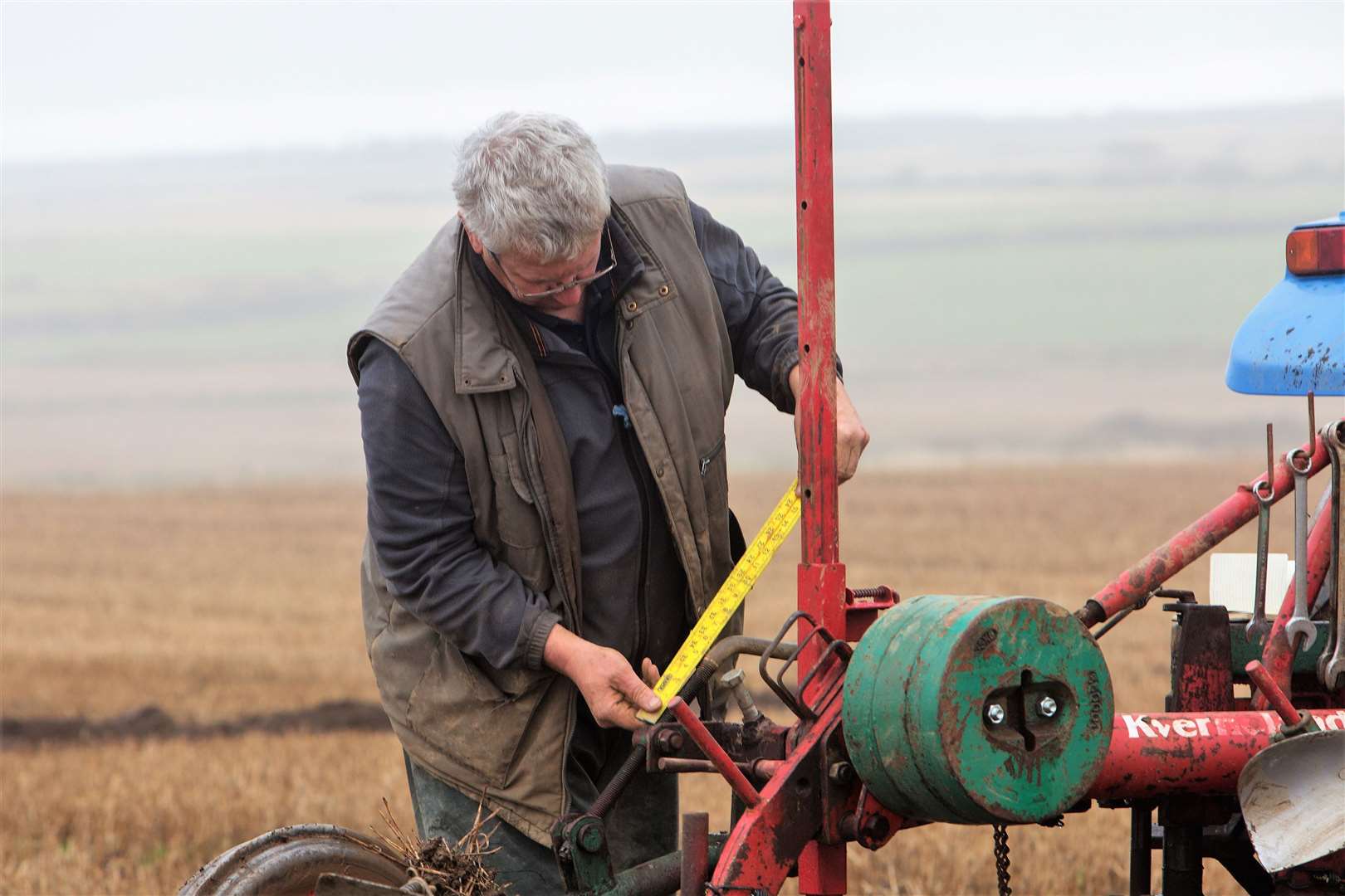 Gordon Rae, Lockerbie, checks the settings on his Kverneland plough. Photo: Robert MacDonald/Northern Studios