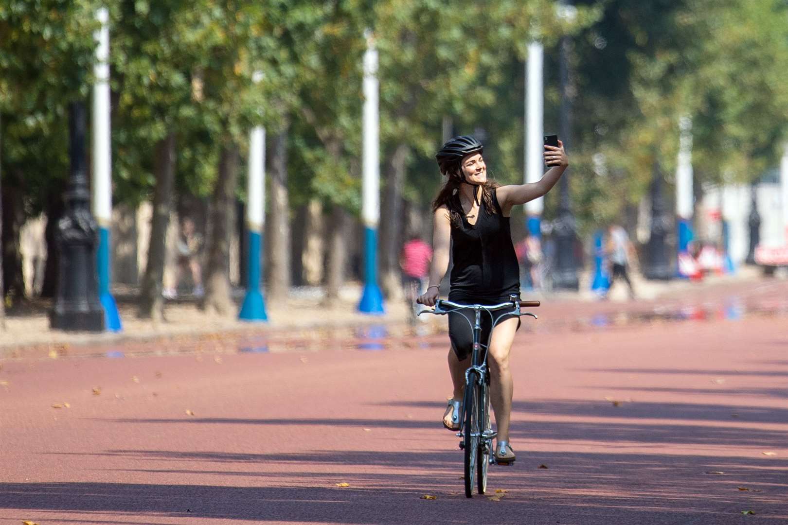 A cyclist takes a selfie on the Mall in central London on August 9 (Dominic Lipinski/PA)