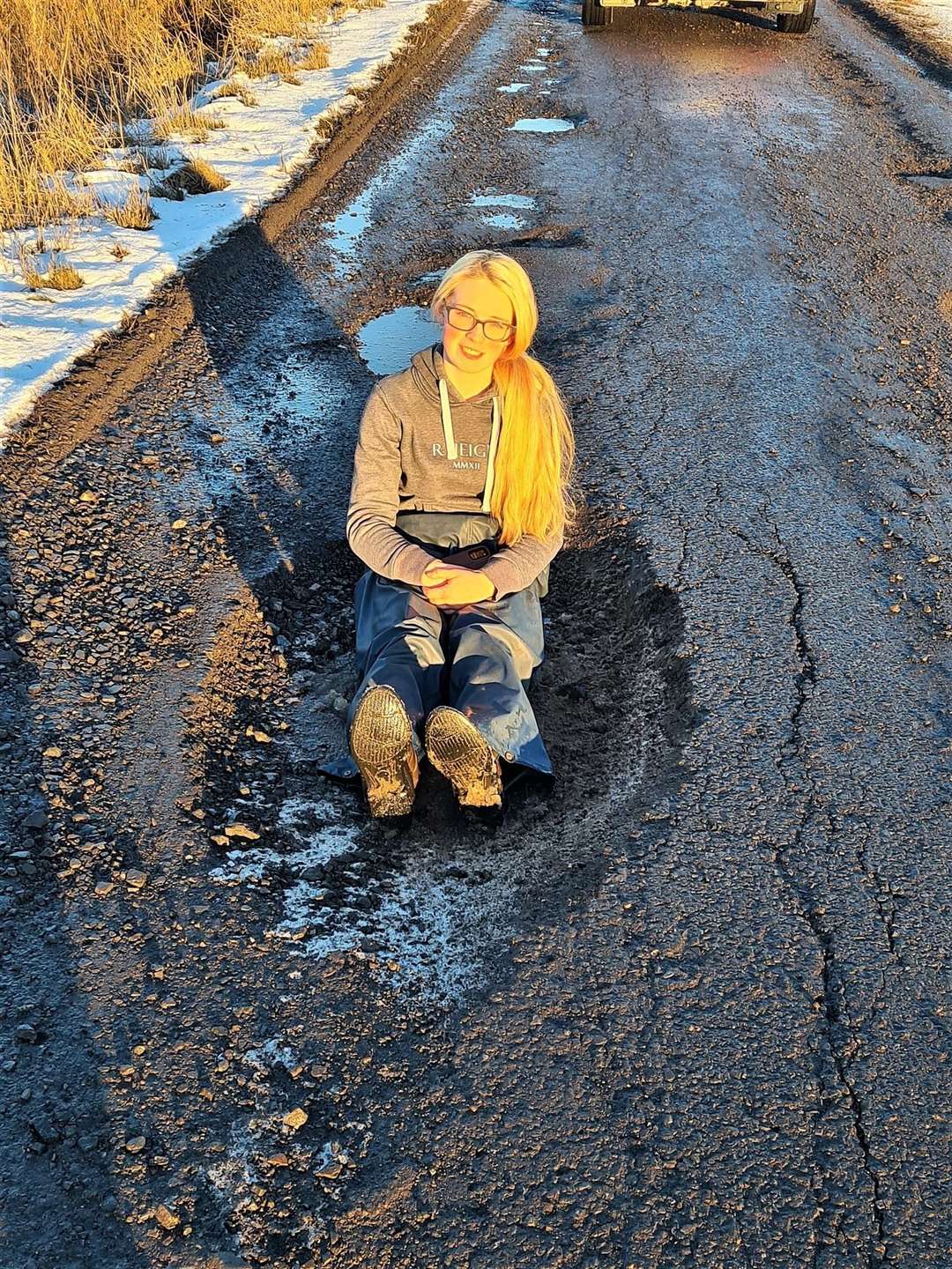 Megan Gillon joked that she could have a bath in the monster pothole so her mum took a picture of her sitting in it. Pictures: Kirsty Gillon