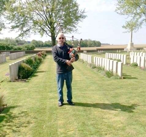 Ernie plays the pipes as a tribute to his granduncle at Nine Elms Cemetery.