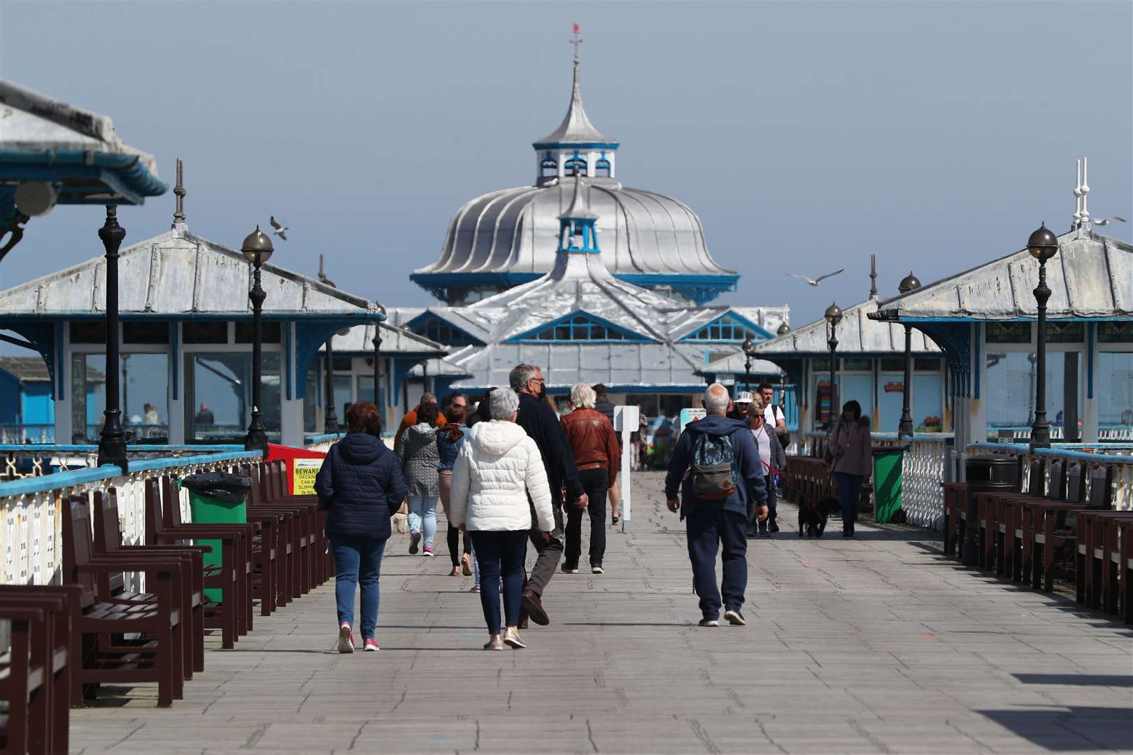People walk along the pier in Llandudno, Wales, where lockdown restrictions have eased (Peter Byrne/PA)