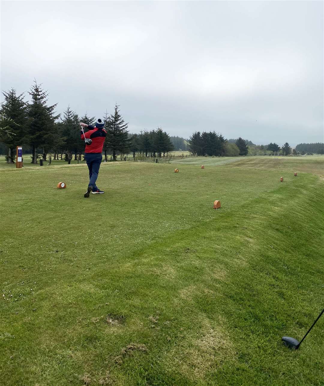 One of the players teeing off in cloudy, overcast conditions at Thurso Golf Club.