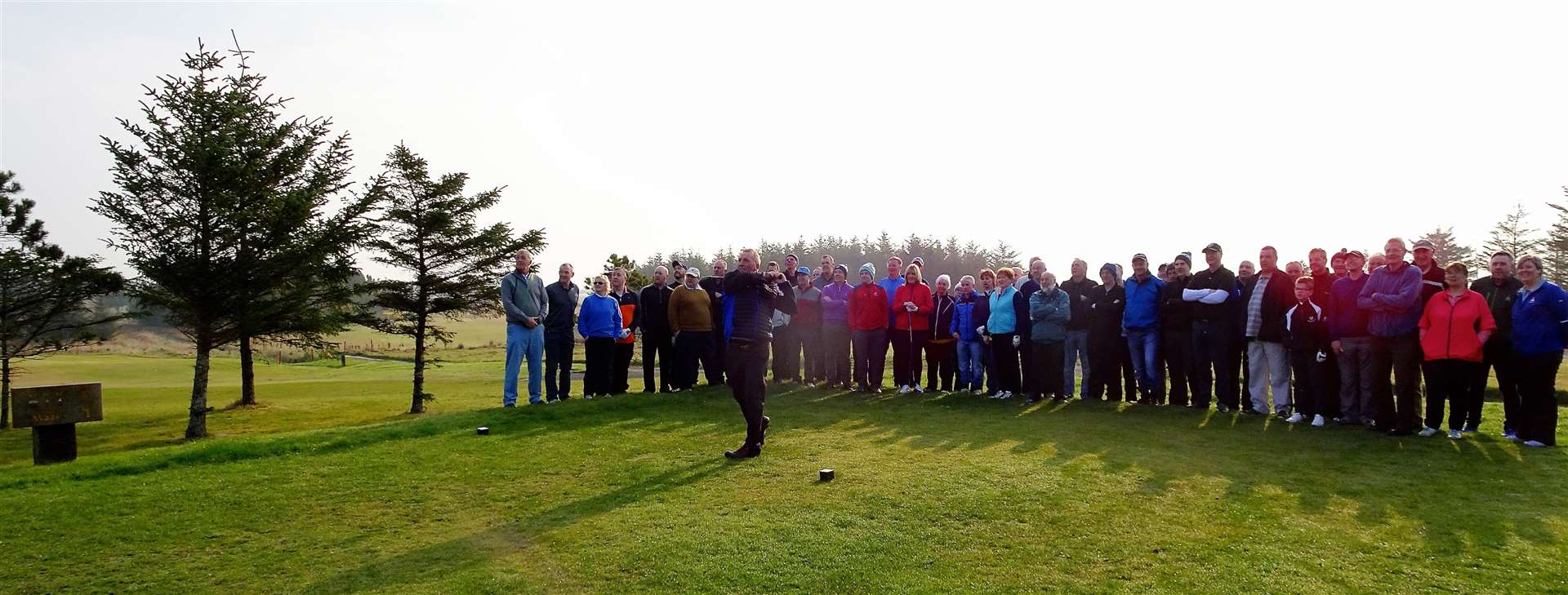 Captain Jocky Begg teeing off, with other Thurso members looking on.