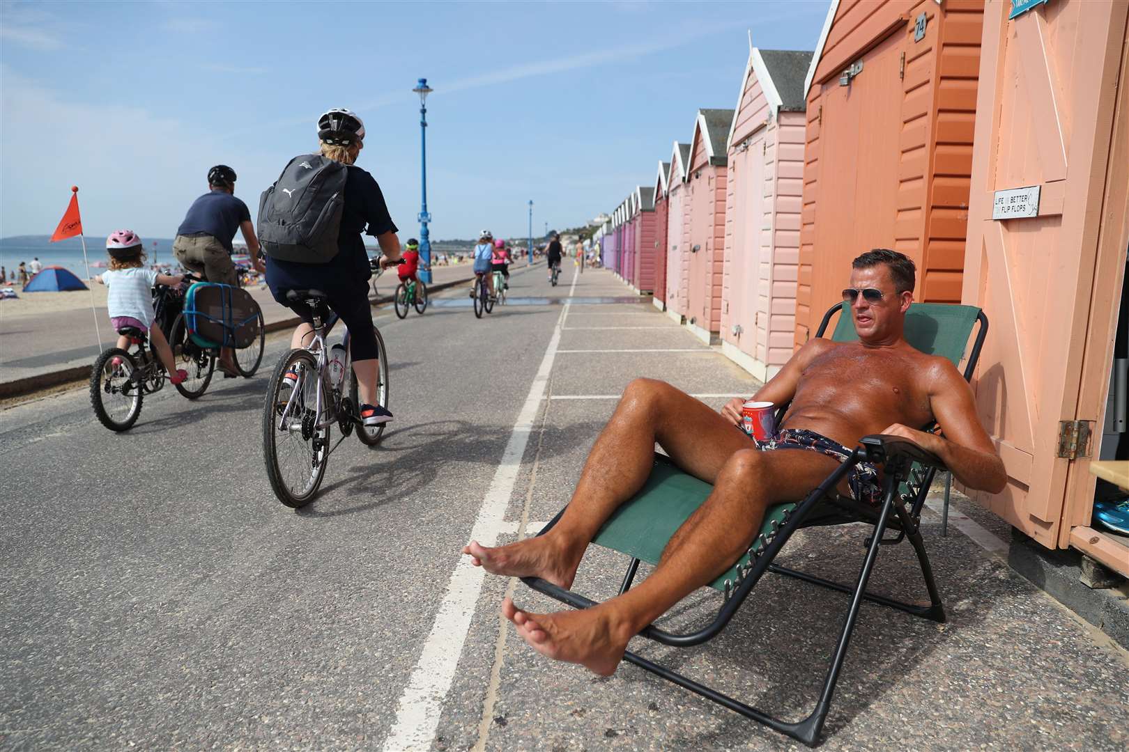 Soaking up rays outside a beach hut at Bournemouth on August 8 (Andrew Matthews/PA)