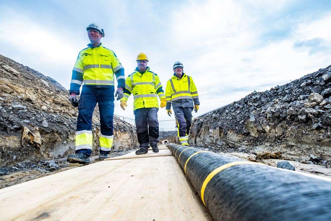 NKT and SSEN Transmission project team members inspecting the cable at Noss Head. From left: Nigel Walker, NKT project installation manager, Brian Barnard, SSEN Transmission marine construction manager, and Mason Douglas, NKT site manager.