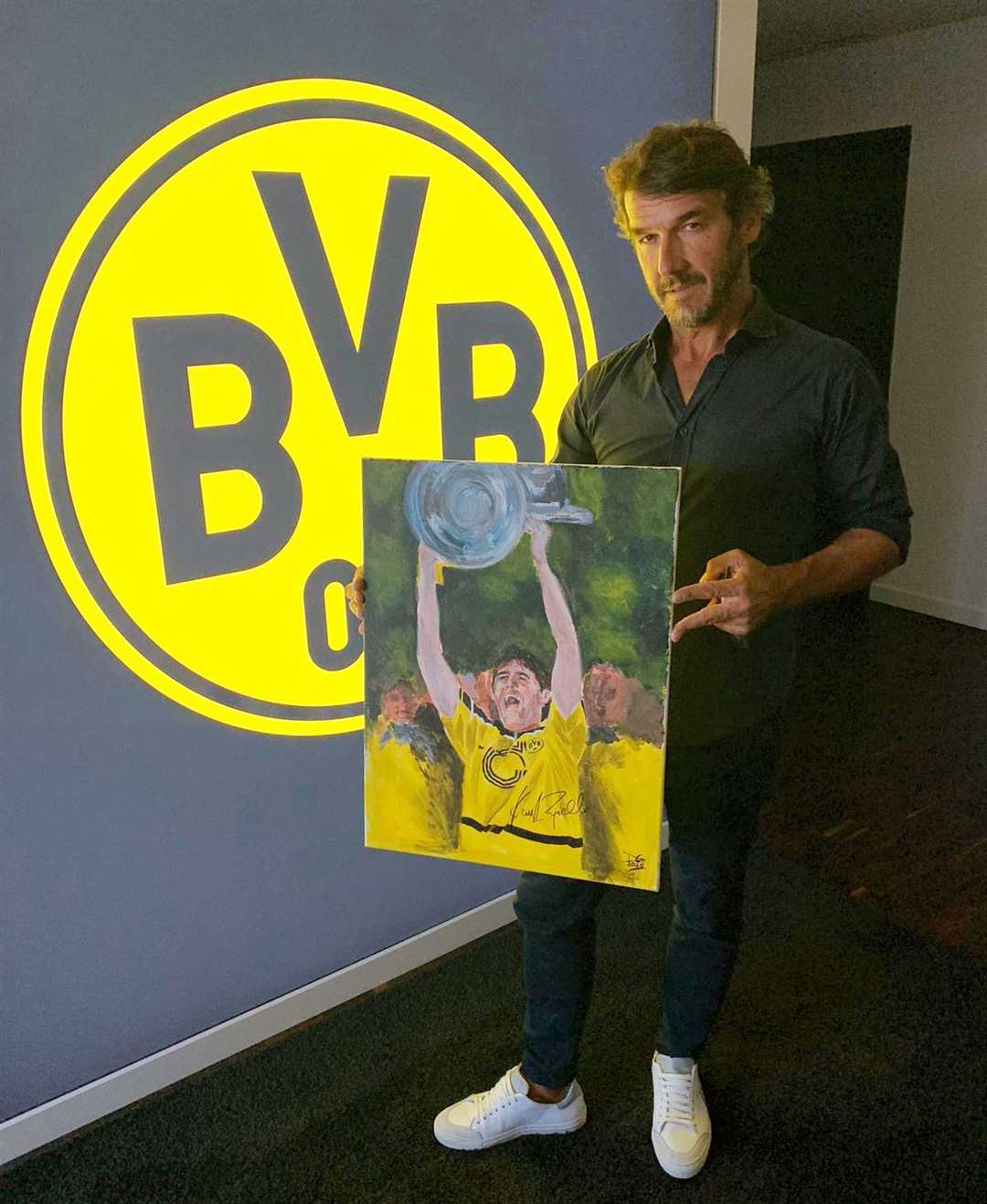 German star Karl-Heinz Riedle after signing the painting by local artist Davie Greig.