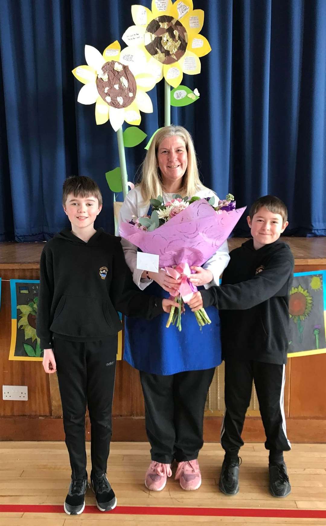 Catriona Manson, along with Liam Macgruer and Kody Munro from P7, who presented her with flowers on her last day of work after 15 years of cooking lunches at Mount Pleasant.