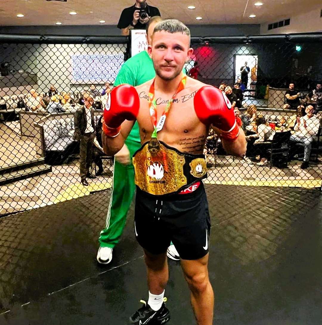 Luke McDowall wears the featherweight championship belt after the recent cage boxing fight.