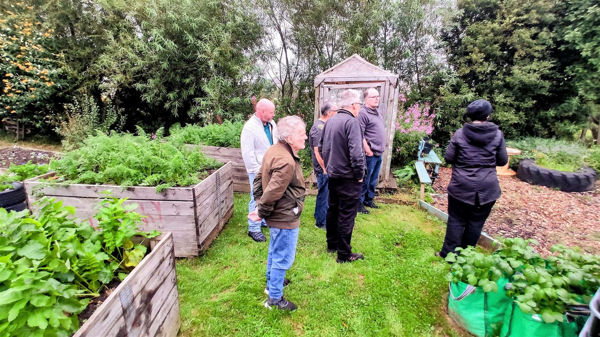 Sharon Dismore from the Thurso Community Development Trust talks with men from the JiM group at the garden project in Thurso.
