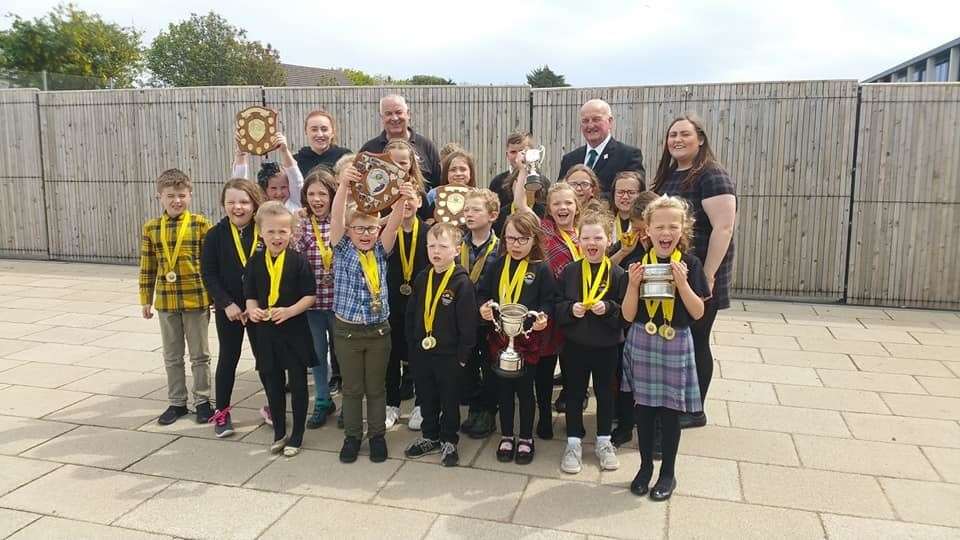 Gaelic medium pupils from Mount Present Primary School in Thurso celebrate their success at the Caithness and Sutherland Provincial Mòd at the East Caithness Community Campus in June. Looking on are Councillor Raymond Bremner, Councillor Willie Mackay and teacher Lynsey Munro.