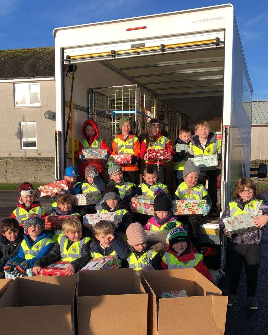 P2 pupils help load the boxes onto the Blythswood van for delivery.