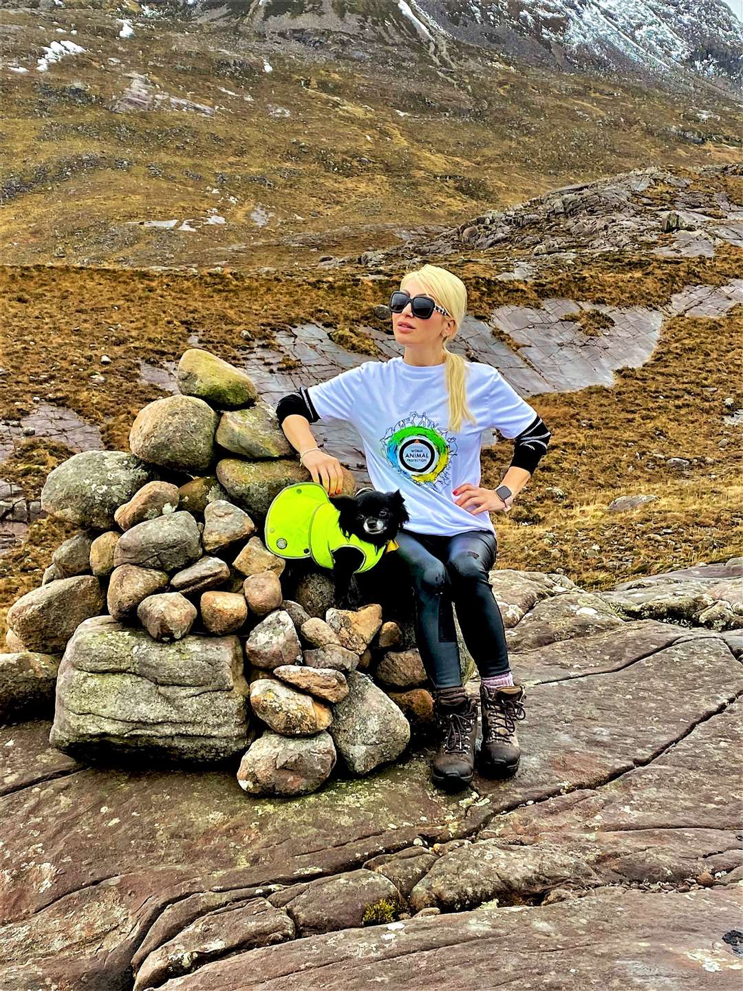 Striking a pose at a cairn by the mountain.