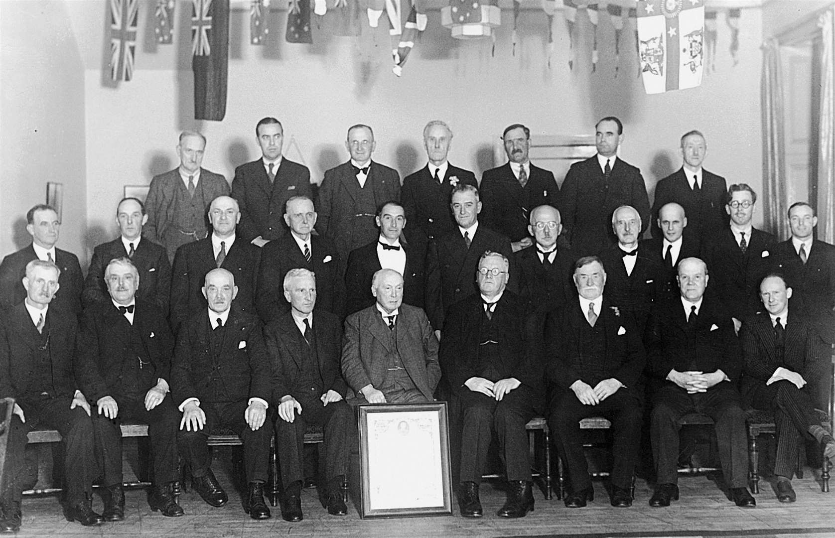 Daniel Wares Georgeson (seated in front, behind the framed picture), who founded the Wick legal firm D W Georgeson and Son in 1887, at a gathering with other pillars of the community.